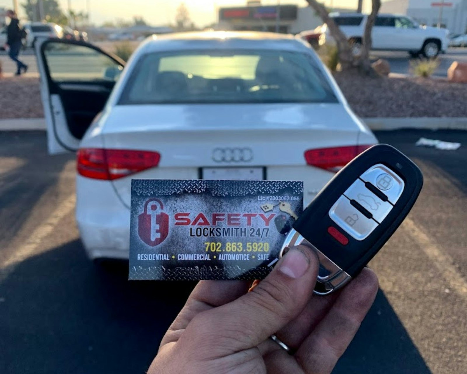 Person holding a car key in front of a white car
